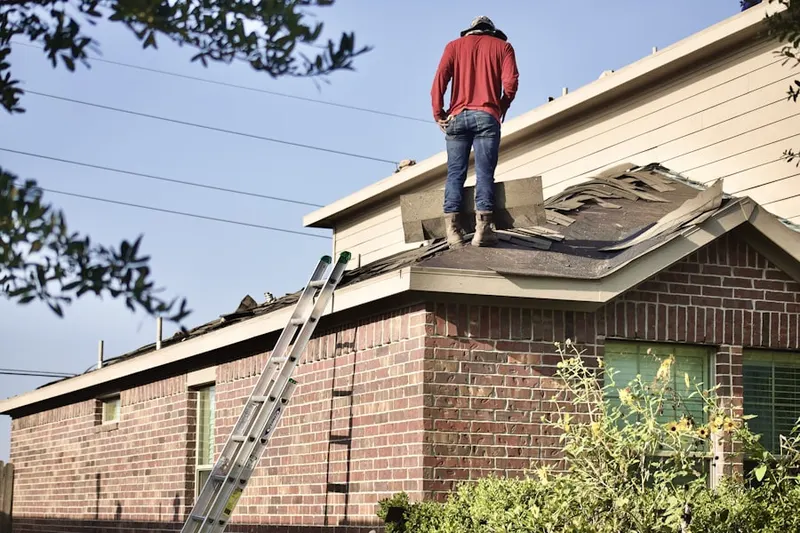 Professional roofer working on a residential roof in Purdys
